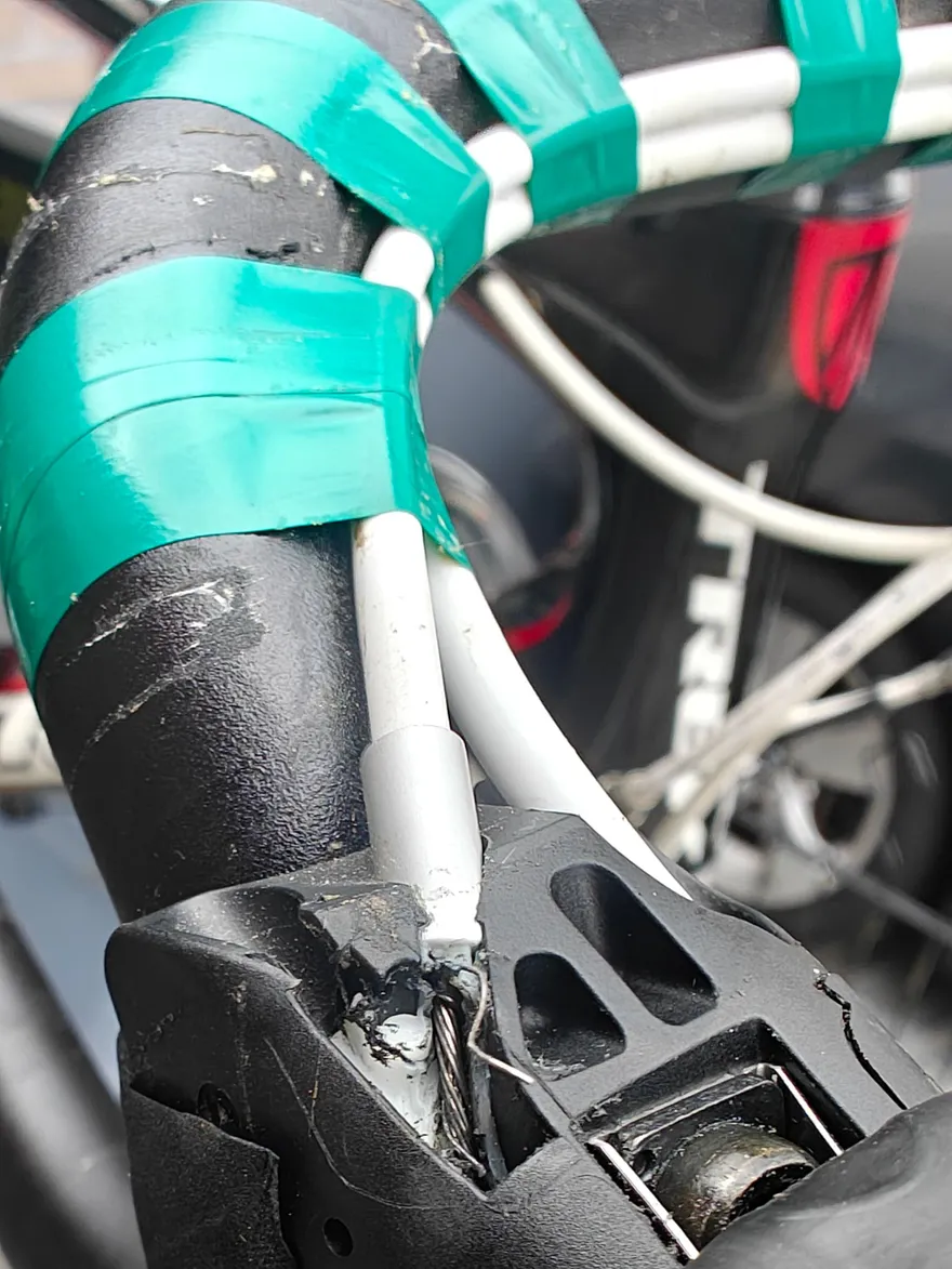 Versleten versnellingskabels aan een stuur, de kabel rafelt uit bij de remgreep