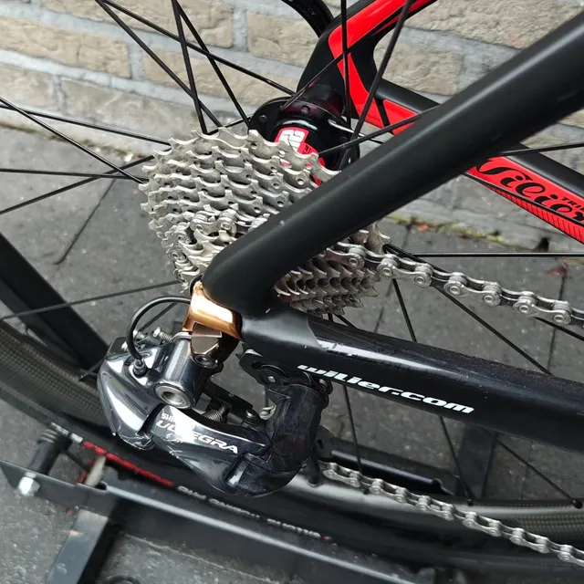 Ketting, cassette en Ultegra-achterderailleur van een Wilier voor de bakstenen muur