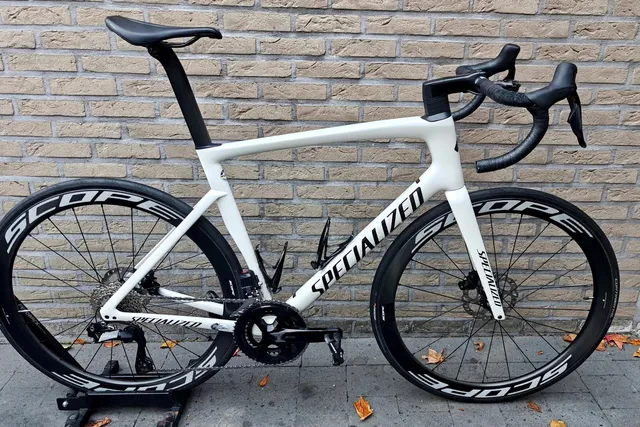 Witte Specialized met hoge carbonvelgen voor de bakstenen muur