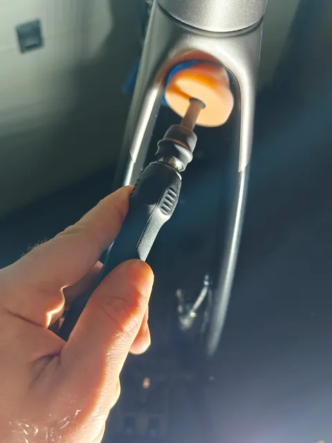 Hand met een kleine polijstmachine aan de binnenkant van een voorvork
