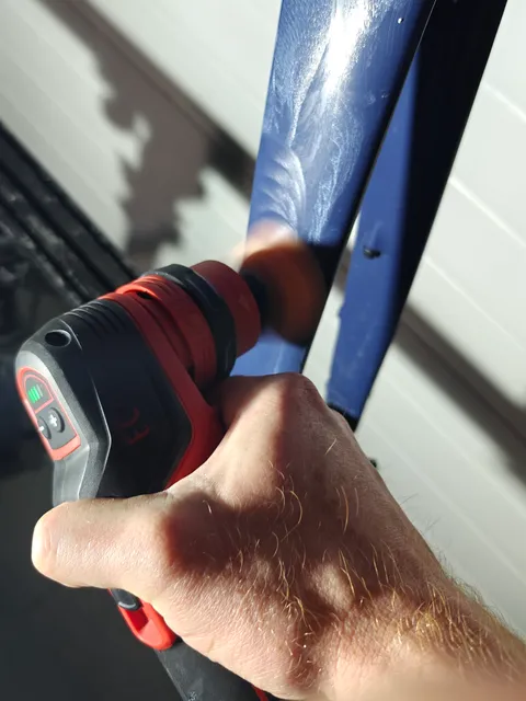 Polijstmachine op de buis van een blauw frame