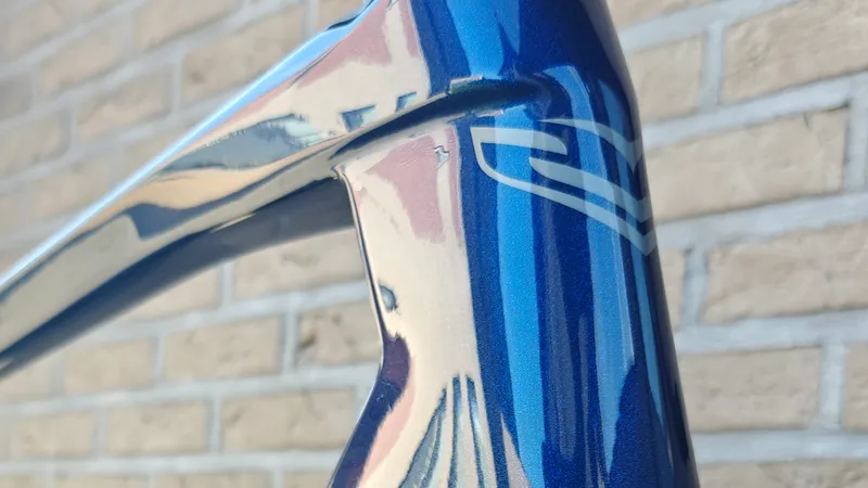 Balhoofd van een blauwe Sensa met diepe glans na de coating, de bakstenen muur spiegelt in de lak